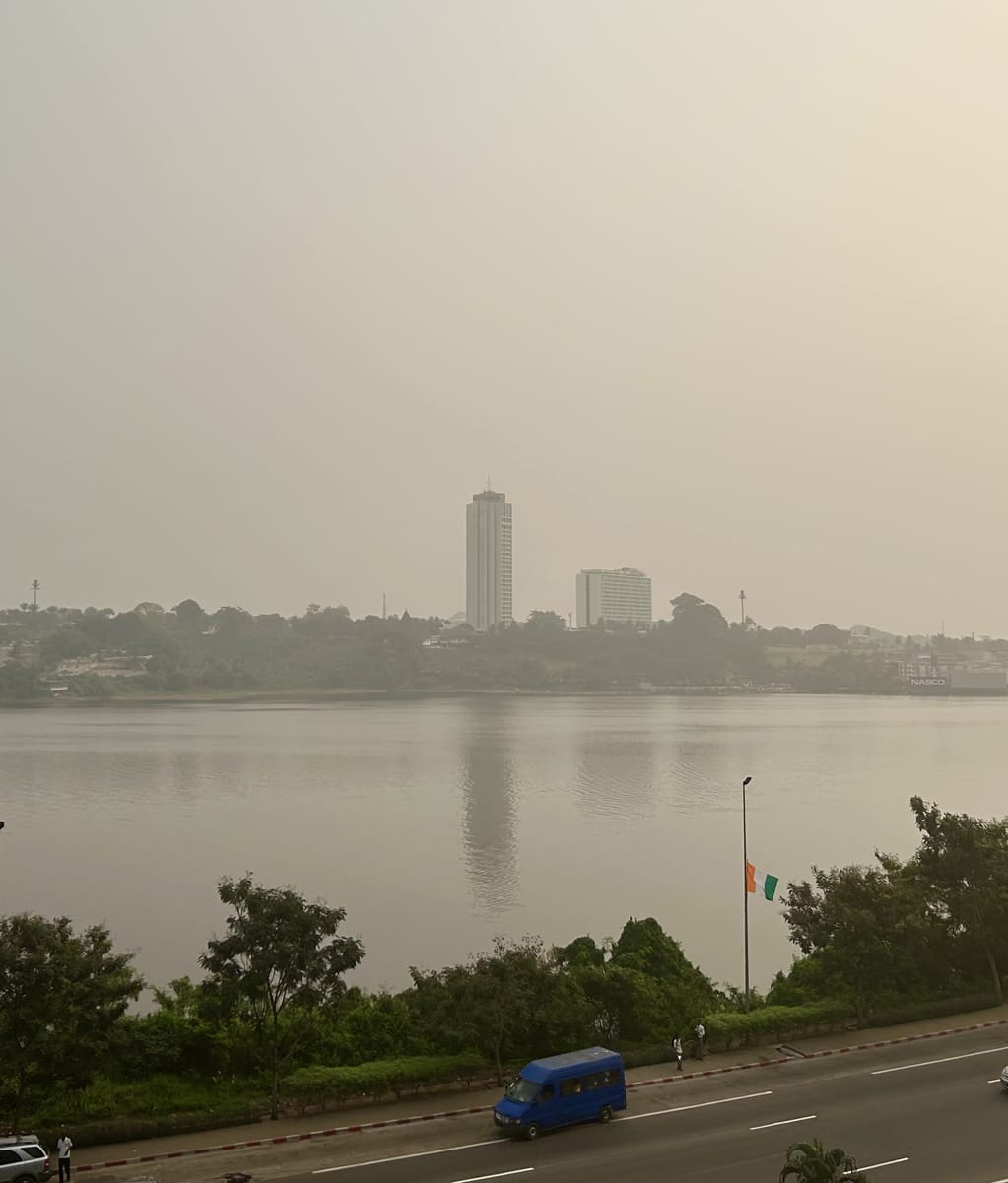 A road in front of a foggy river