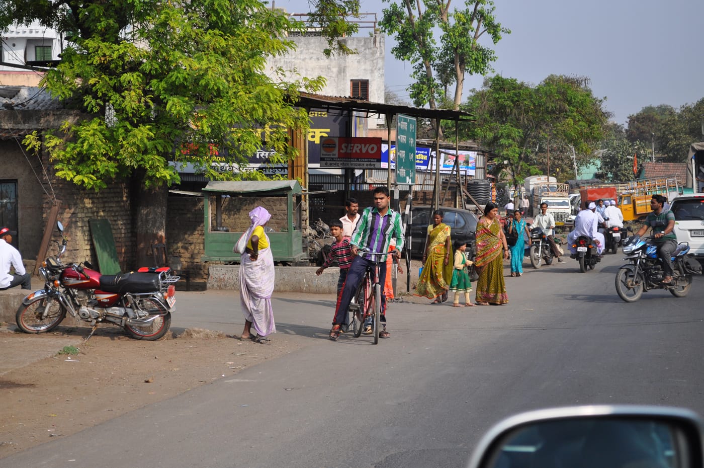 A man and a boy on a bicycle on a street in India
