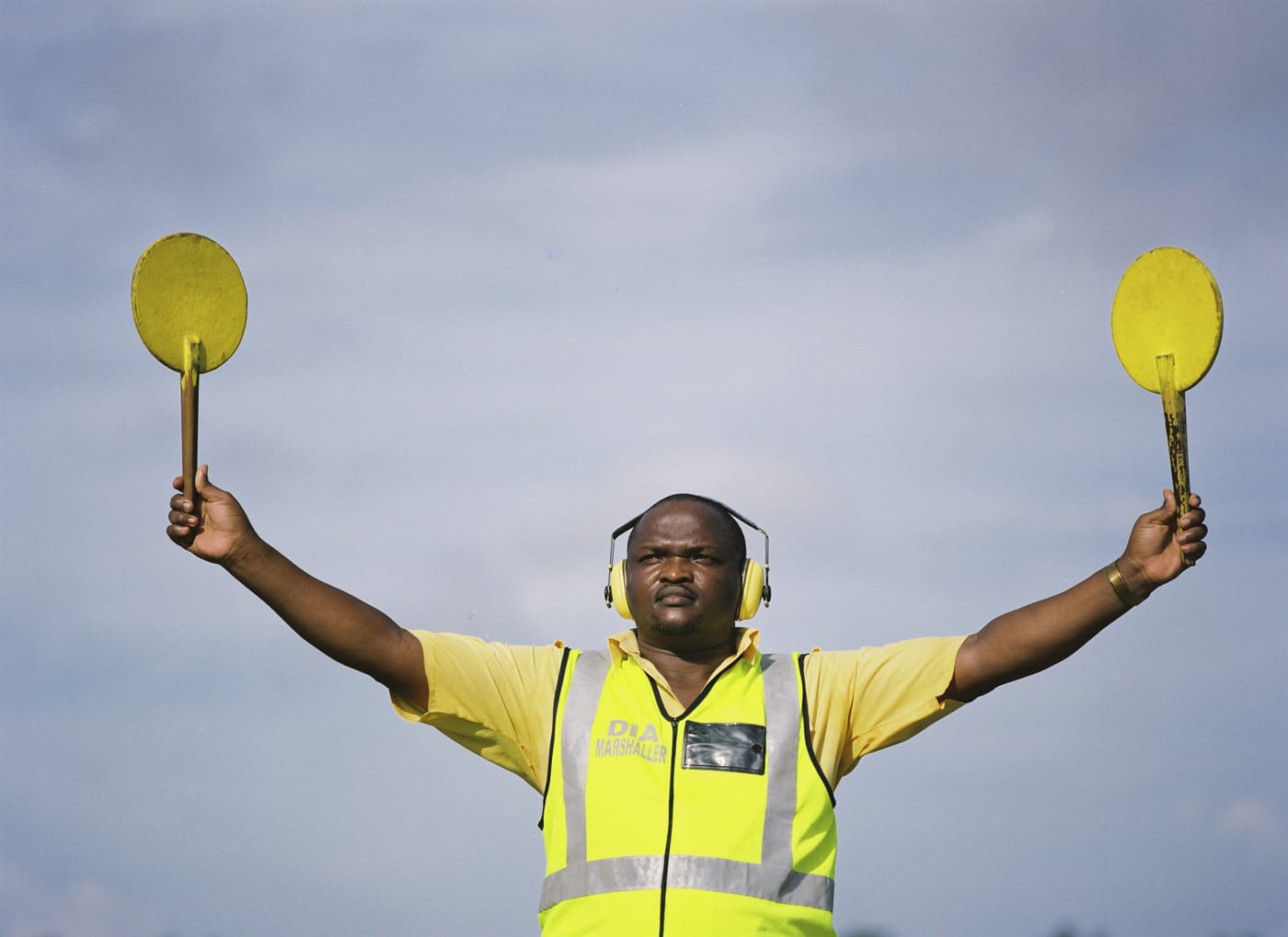 Man signaling with yellow sticks