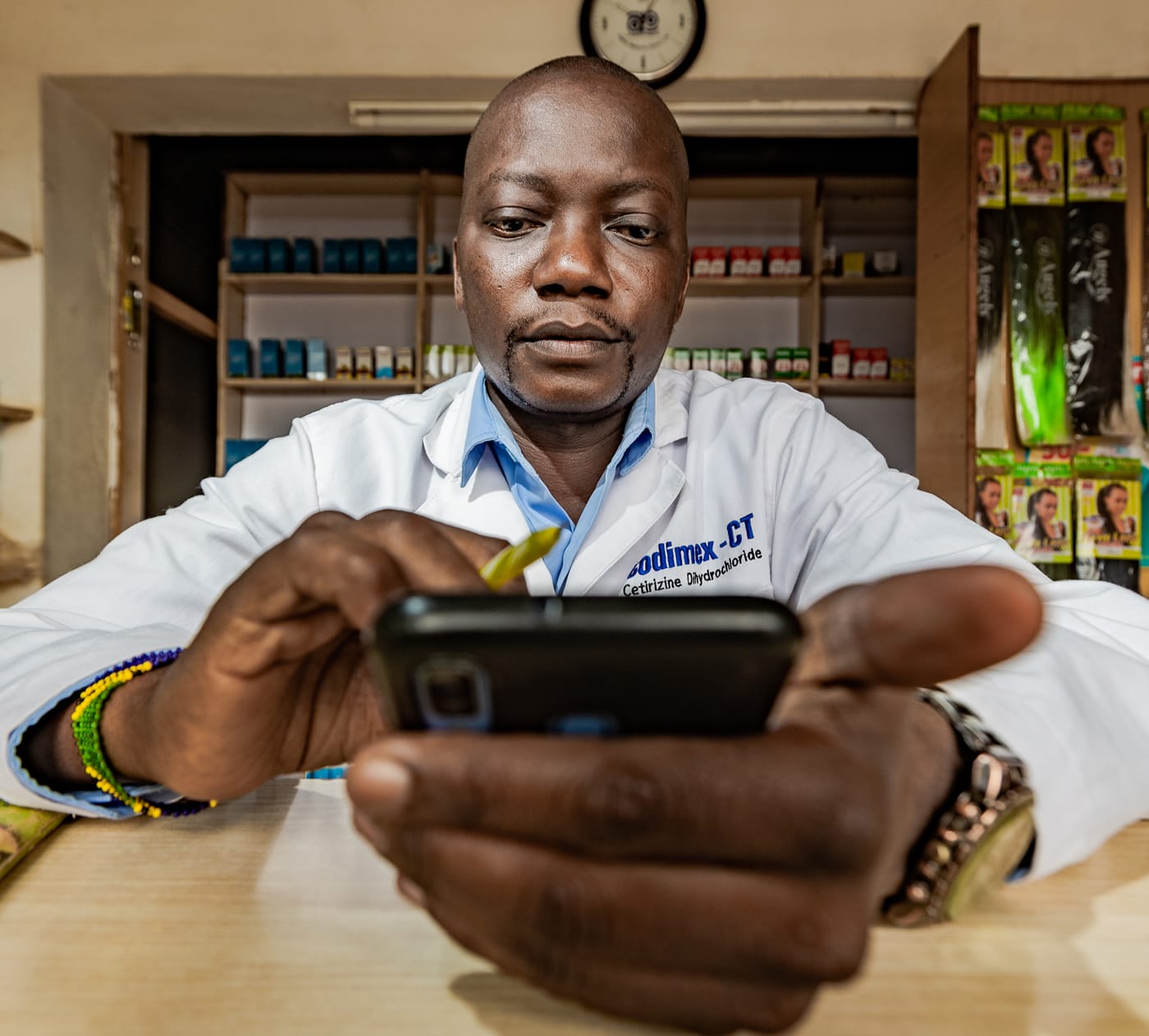 Pharmacist in store watching his phone