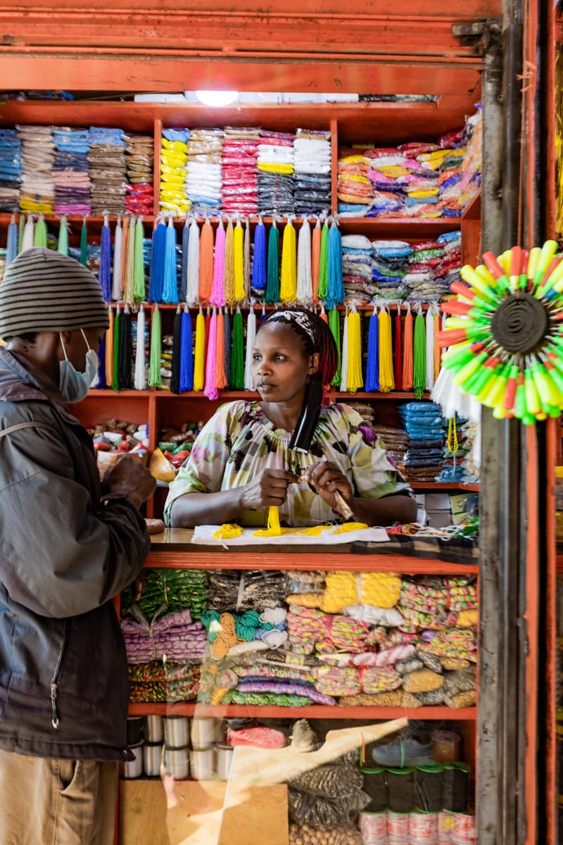 A man and a woman talking in front of a colorful store